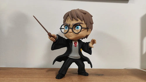 Figurine 3D Harry Potter avec lunettes rondes, robe noire et baguette levée, vue de face.
